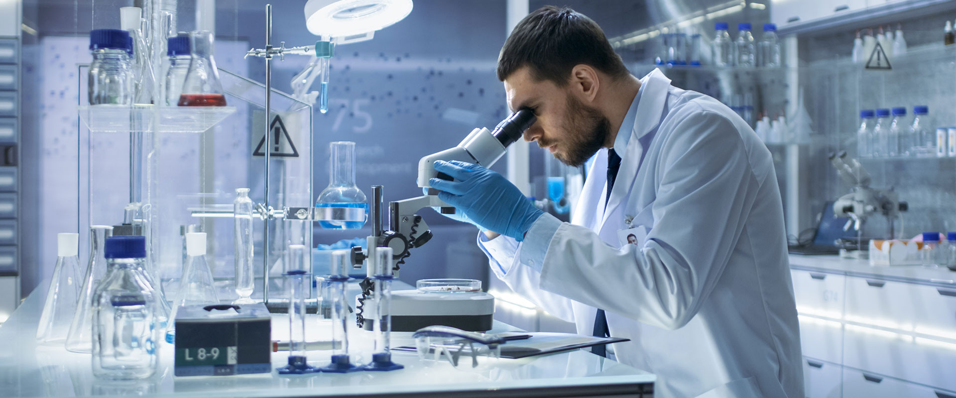 Background image of a researcher in a lab.